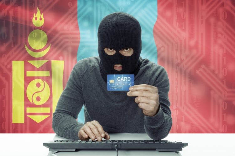 モンゴル国旗の前にマスクをした男がいてクレジットカードを持っている写真