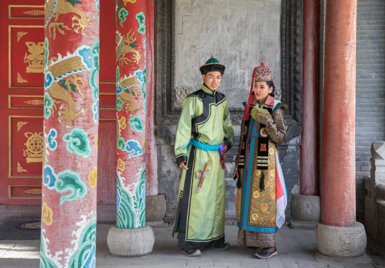 モンゴルの伝統的な衣装を着たカップルが二人で立っている写真