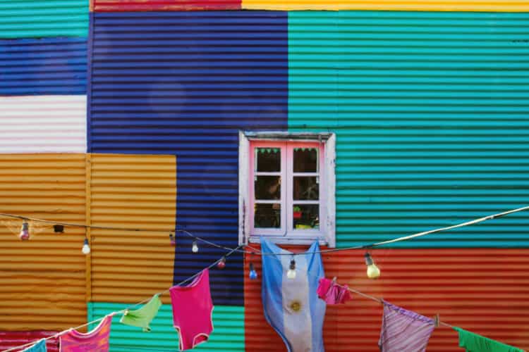 カラフルな壁に洗濯物とアルゼンチン国旗が掛かっている写真