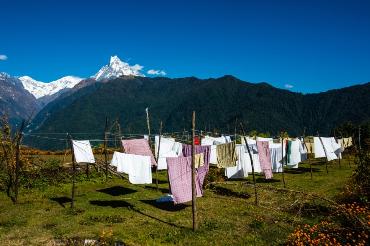 背景に山が見える場所で洗濯物がたくさん干されている写真