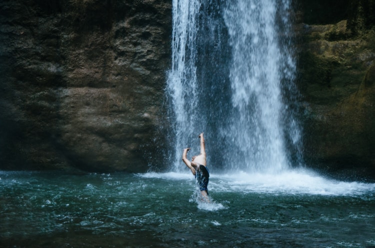 滝の前で男性らしき人が遊んでいる写真