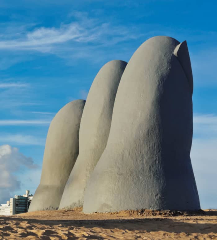 巨大な指の形の石像が３つビーチに立っている写真