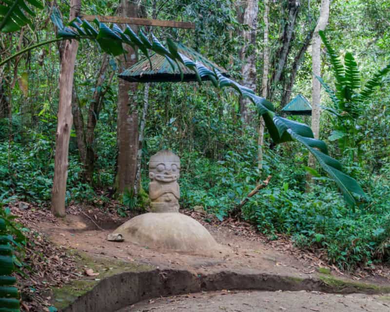 森の中に石彫りの像が１つ立っている写真