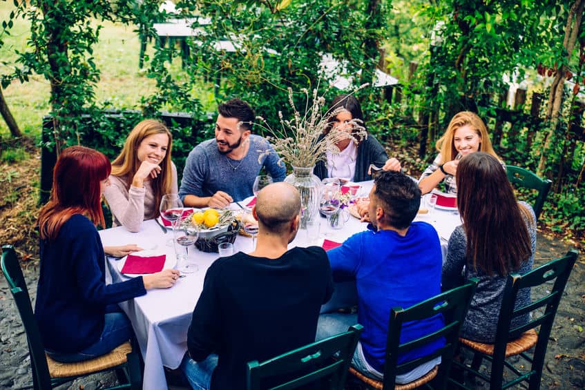 野外でイタリア人の家族がテーブルを囲んでいる写真