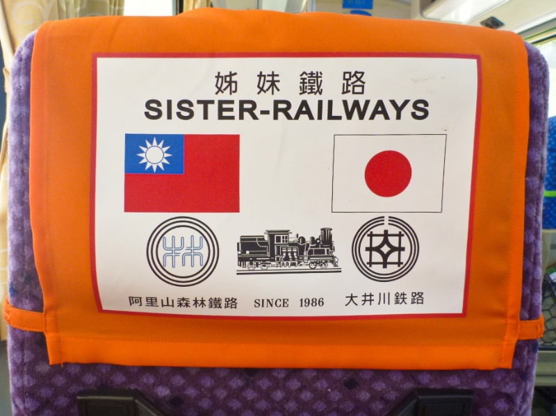 列車のシートの後ろに台湾国旗と日本国旗。姉妹鉄道の文字