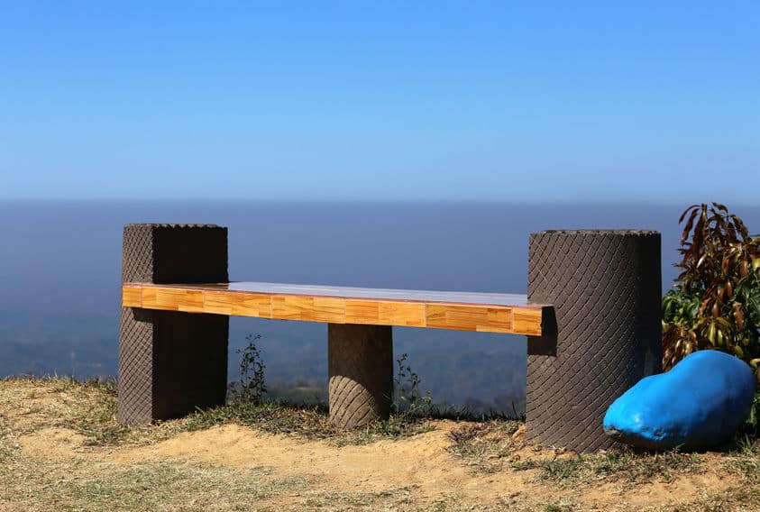丘の上で木のベンチが一つある写真