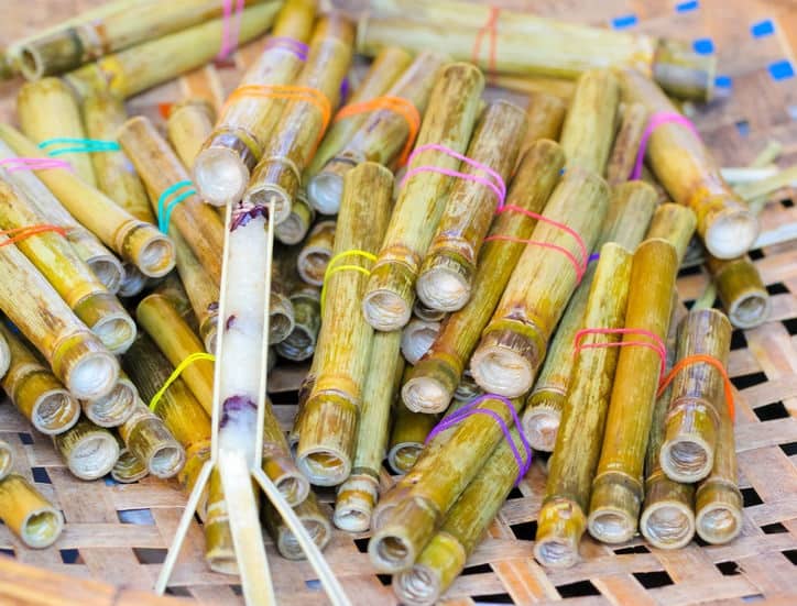 カオラム。細めの竹に米や小豆が詰められている料理の写真