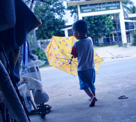 小さい子どもが傘を開こうとしている写真